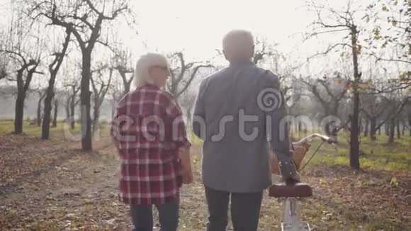 在雾蒙蒙的森林里骑着自行车行走的高加索族夫妇的后景快乐的退休老人家庭支出视频的预览图