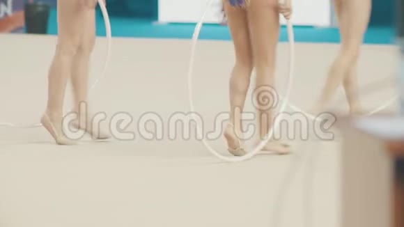 年轻女子在艺术体操比赛中的双腿站在舞台上抱着圈走视频的预览图