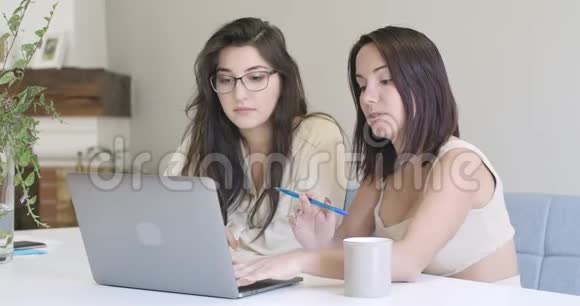两个聪明的白人年轻女人在电脑上打字聊天自信的聪明女孩在家在线工作电影院视频的预览图