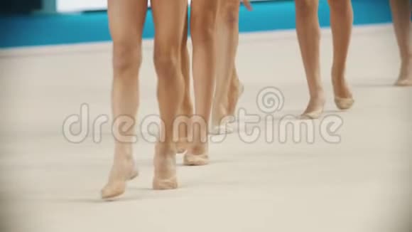 在艺术体操比赛中年轻女子的双腿穿着尖鞋走在舞台上视频的预览图