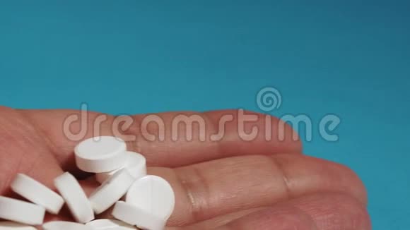 手掌上握着各种白色药丸药物片剂的特写手中的胶囊男人吃药视频的预览图