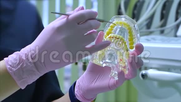 女牙医在诊所为女病人治疗牙齿牙医向病人展示下颚模型如何视频的预览图