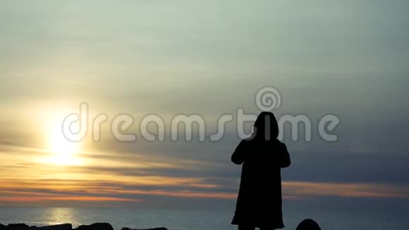 白种人在海滩上的肖像日落时用电话拍摄海边的海洋视频的预览图