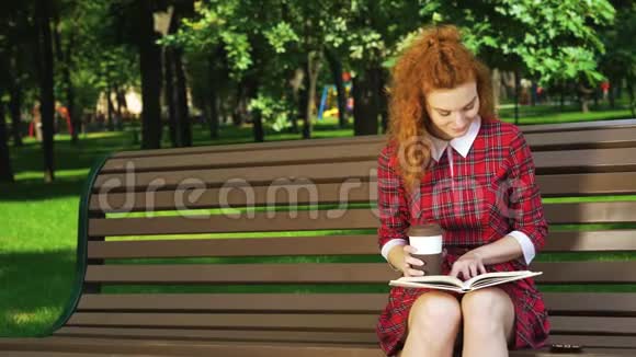 红头发的学生在公园里学习喝咖啡视频的预览图