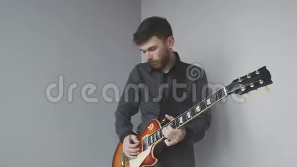 有胡子的男子独自演奏电吉他双手演奏电吉他为摇滚音乐会练习视频的预览图
