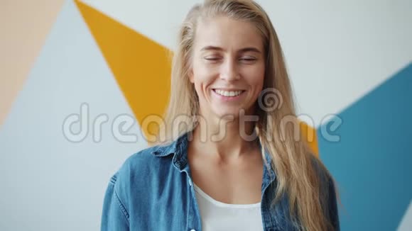 一位金发美女站在室内微笑着慢动作视频的预览图
