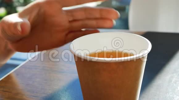 女人的手从桌子上拿着一杯茶视频的预览图
