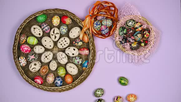 彩色鸡蛋放在一张桌子上靠近一篮子蓝色背景的复活节彩蛋复活节是神圣的4k视频的预览图