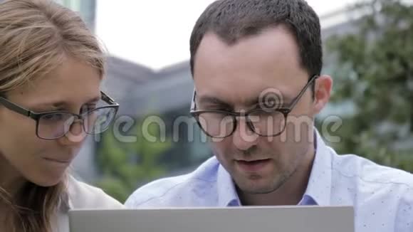 快乐商务夫妇使用笔记本电脑户外视频的预览图