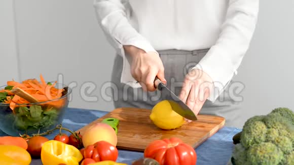 女人正在厨房的木切割板上切柠檬视频的预览图