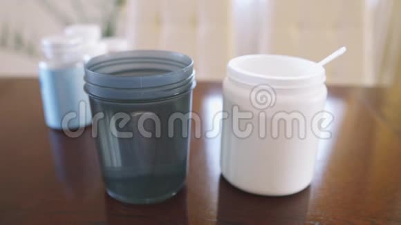 男人在餐桌上的摇床里做一种与水混合的饮食蛋白鸡尾酒视频的预览图