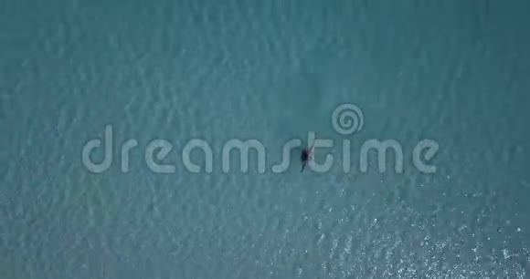 站在萨尔达湖蓝色水域的人的俯视图旋转4k视频的预览图