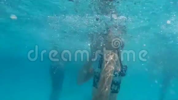 水下观看少年女孩的护目镜在游泳池游泳人们在透明水上度假酒店游泳水下视频的预览图