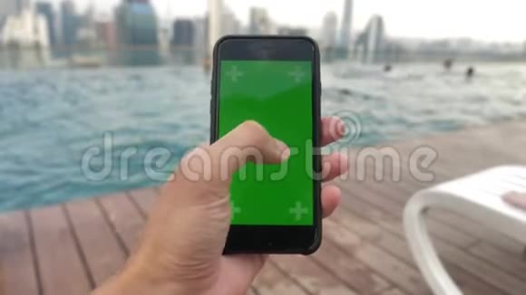 用绿色屏幕色度键关闭智能手机靠近游泳池在触摸屏上观看视频并跟踪视频的预览图