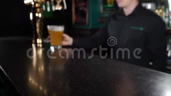 酒吧柜台的Tapster拿出一杯啤酒并向客户展示快关门酒保把一杯视频的预览图