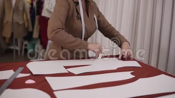 专业的女裁缝在餐桌上用红布在阿泰利耶工作熟练的女裁缝画素描线视频的预览图