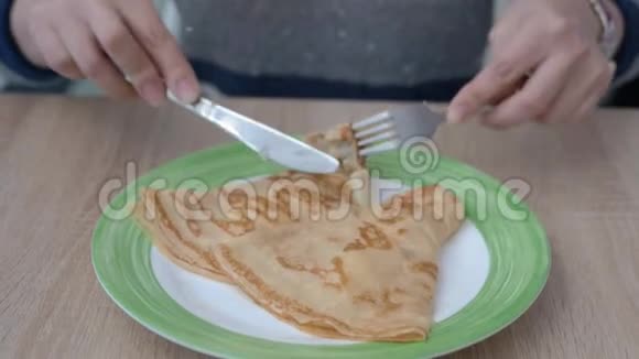 盘子里有两个薄饼女性白种人用刀叉切视频的预览图