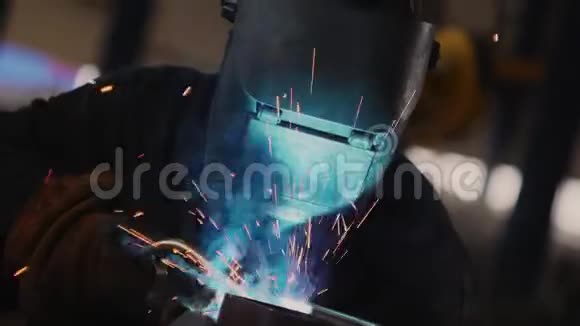 特殊面罩的焊工将金属部件连接在明亮的火花处视频的预览图
