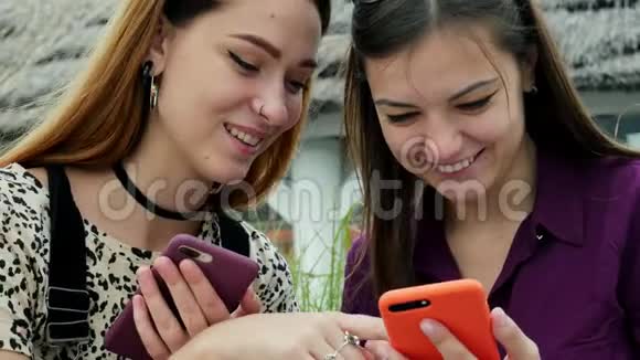 特写两位有魅力的年轻女性用手机看照片笑朋友们享受美好时光视频的预览图