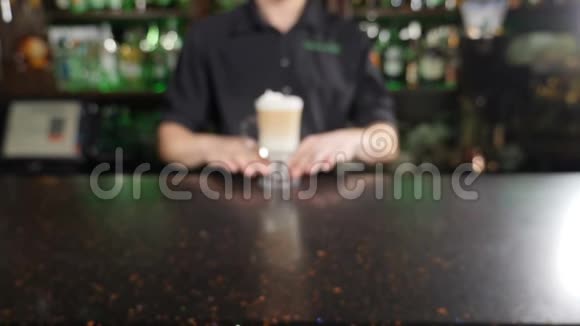 男咖啡师的特写拿着一个刚刚准备好的带吸管的芳香拿铁酒保在煮咖啡咖啡饮料视频的预览图