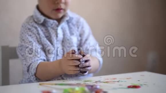 一个小小的孩子剥去漆成复活节彩蛋的外壳视频的预览图