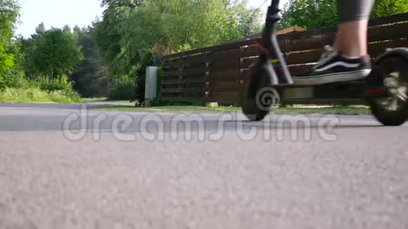 一对年轻漂亮的夫妇一个和她男朋友在一起的女孩在城市公园里骑电动滑板车极低的照相机视频的预览图