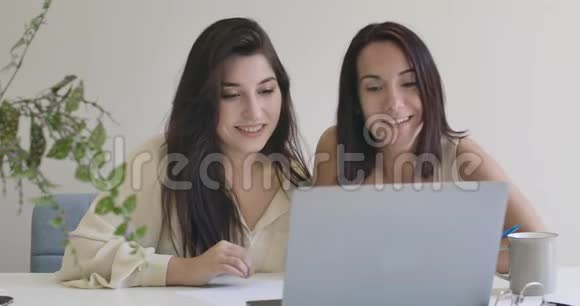 两个可爱的白人女孩用笔记本电脑和视频通话自信的年轻女性朋友或姐妹聊天视频的预览图
