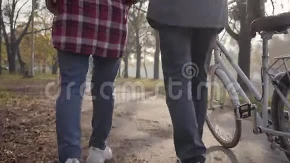 在公园里两双成年腿穿着运动鞋骑着自行车沿着小巷行走摄像机开了已退休视频的预览图