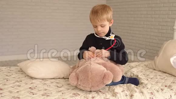 一个小男孩正在卧室里玩玩具熊和听诊器视频的预览图