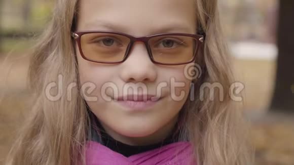 一个害羞的白人少女的特写肖像看着相机微笑着光致变色女学生视频的预览图