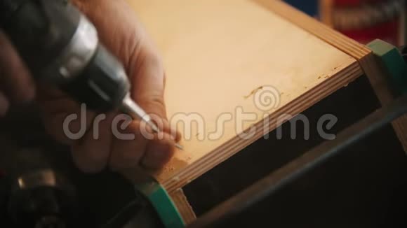 木工行业工人将螺丝钻入车间的胶合板上视频的预览图
