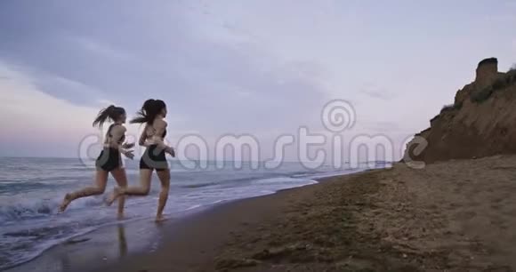 漂亮的女士与健康的身体一起跑在海滩旁享受这一时刻缓慢的动作视频的预览图