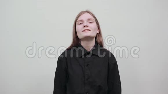 年轻的金发女人穿着黑色衬衫双手并拢祈祷着抬头看着视频的预览图