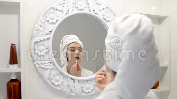 女人在浴室用唇刷在嘴唇上涂口红视频的预览图