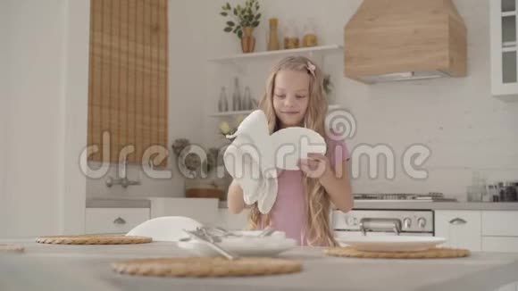 年轻脾气暴躁的白人少女穿着粉红色连衣裙擦盘子用毛巾把它扔到桌子上视频的预览图
