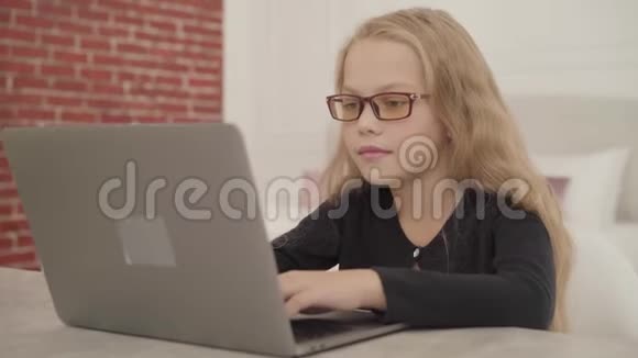 一个戴着眼镜的白人少女戴着笔记本电脑坐在家里合上电脑抱着头的肖像视频的预览图