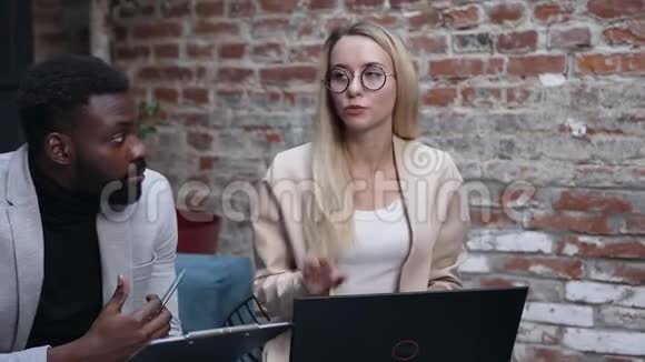 成功的年轻商务女士与他们的团队商务同事一起集思广益用手提电脑谈论新想法视频的预览图