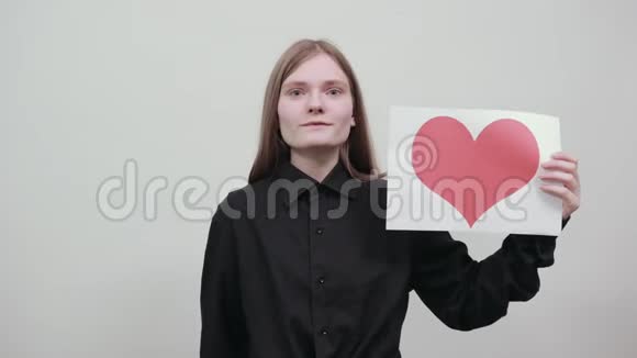 可爱的白种人年轻女人用红心的照片写着纸喜欢它视频的预览图