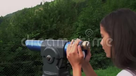 女孩用旅游望远镜看山和树林视频的预览图