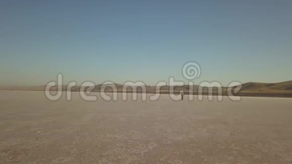 一个人在沙漠中行走的镜头在平原上的高角度视野视频的预览图