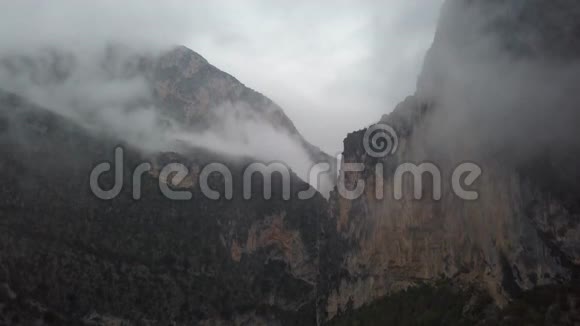 空中拍摄的山顶覆盖着低空飞云的山脉4k视频的预览图