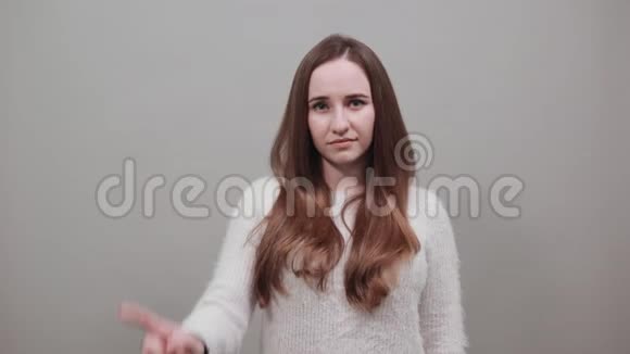 穿毛衣的开朗的女士指着相机保持手在腰带上视频的预览图