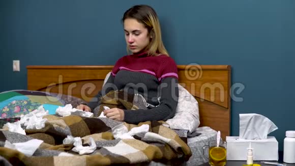 年轻女子喝柠檬茶那个女孩病了躺在床上纸围巾散落一地视频的预览图