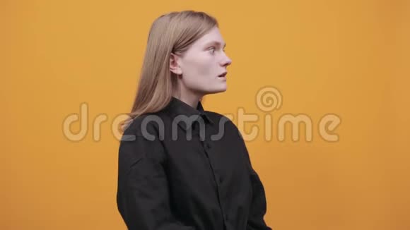震惊的女人穿着黑色衬衫手指向一边保持着张开的嘴视频的预览图
