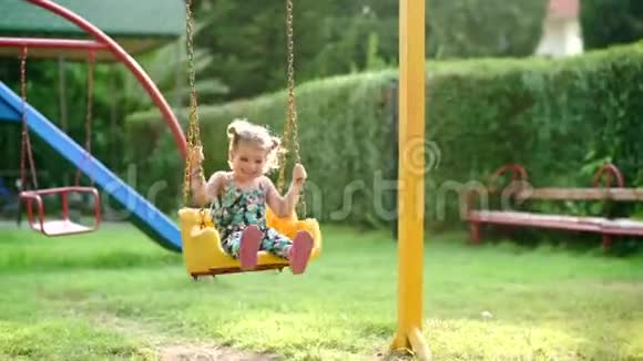 公园秋千上快乐的小女孩视频的预览图