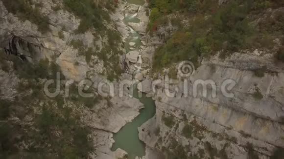 一辆汽车开在一条河上两座山之间的一座大桥上视频的预览图