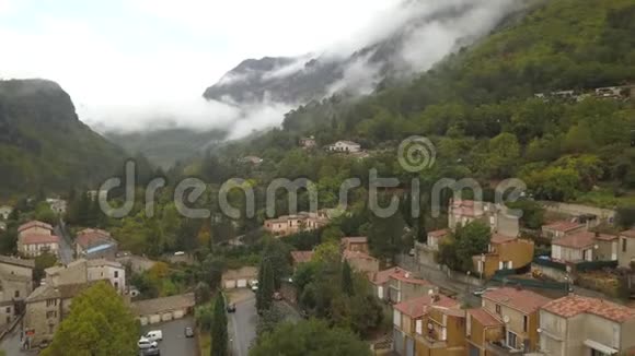 空中拍摄的一个山村与美丽的山脉与云4k视频的预览图