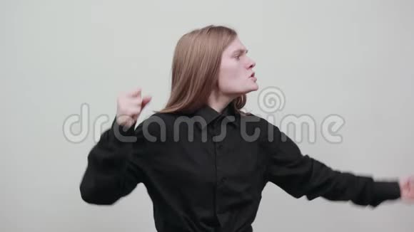 性感的金发女郎穿着黑色衬衫保持拳头打架尖叫视频的预览图
