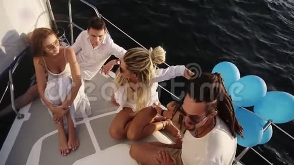 一群年轻快乐的朋友在夏日的游艇船头上航行朋友男人和女人在阳光下放松高视频的预览图