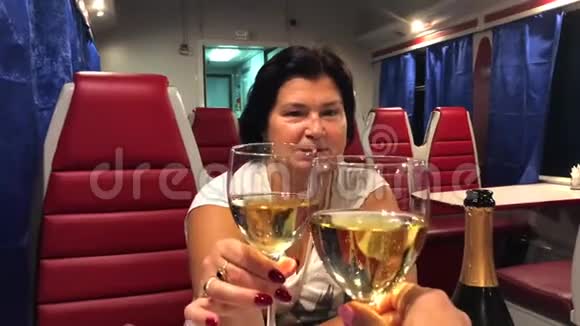两个女人坐在火车餐车里喝香槟视频的预览图